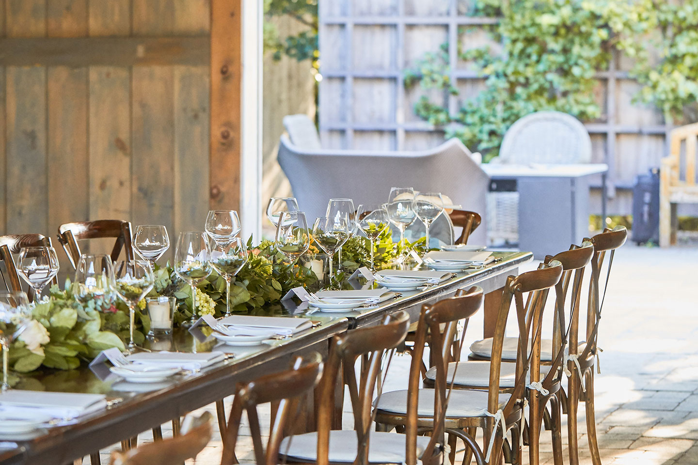 A harvest table prepared for dinner in an outside space
